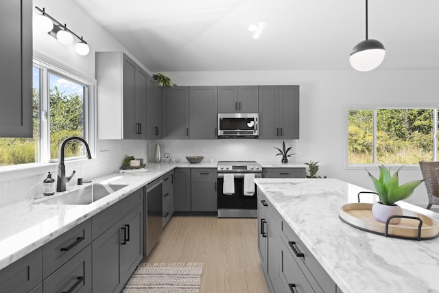 kitchen with decorative light fixtures, gray cabinets, sink, and appliances with stainless steel finishes