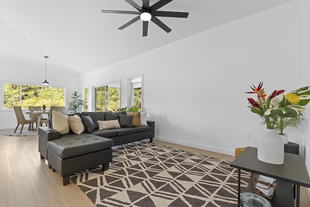 living room featuring ceiling fan, light hardwood / wood-style floors, and lofted ceiling