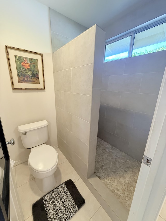 bathroom featuring tile patterned floors, toilet, and tiled shower