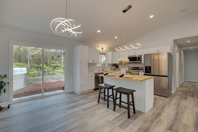 kitchen with pendant lighting, a kitchen island, white cabinetry, and stainless steel appliances