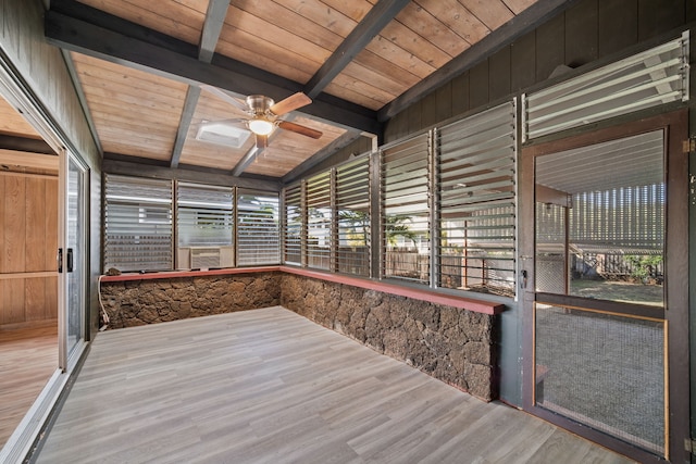 unfurnished sunroom featuring vaulted ceiling with beams, ceiling fan, and wood ceiling