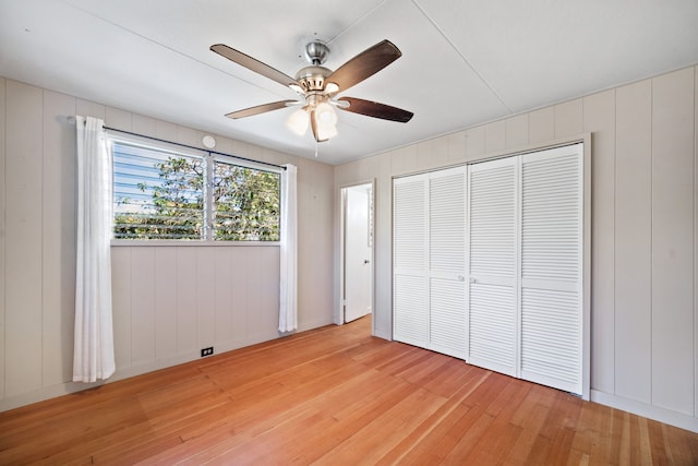 unfurnished bedroom featuring ceiling fan, light wood-type flooring, and a closet