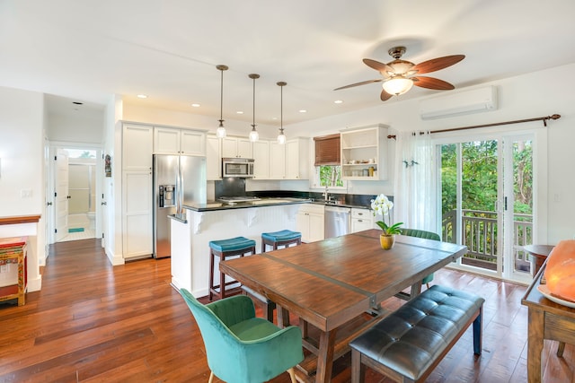 dining area with a wall mounted air conditioner, ceiling fan, dark hardwood / wood-style flooring, and sink