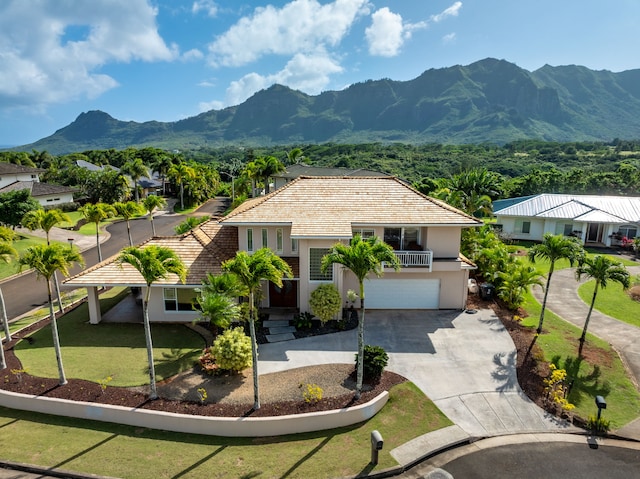 view of front of home featuring a mountain view, a garage, and a front yard