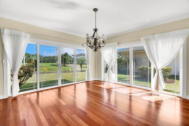 unfurnished dining area featuring a chandelier and wood-type flooring