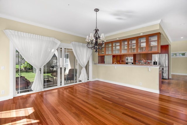 unfurnished dining area featuring ornamental molding, plenty of natural light, and a notable chandelier