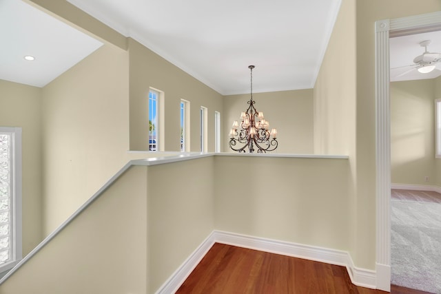 hallway featuring hardwood / wood-style floors, a chandelier, and ornamental molding