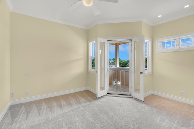 carpeted entrance foyer with ceiling fan and crown molding