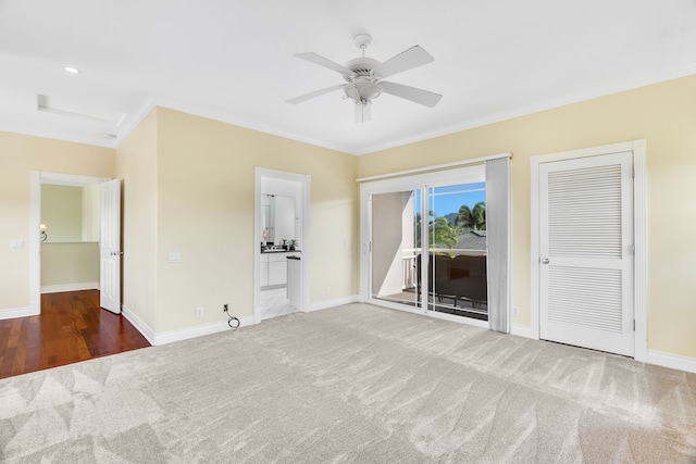 interior space featuring access to outside, dark colored carpet, crown molding, ceiling fan, and connected bathroom