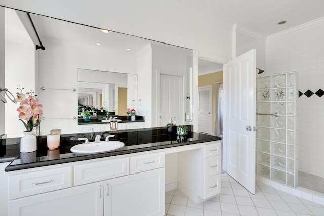 bathroom featuring tile patterned flooring, a tile shower, vanity, and ornamental molding