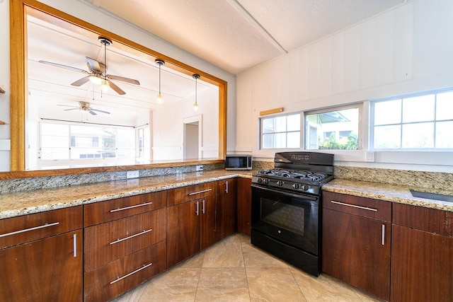 kitchen with pendant lighting, light tile patterned floors, ceiling fan, light stone countertops, and black range with gas stovetop