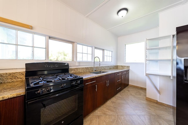 kitchen featuring light stone counters, dark brown cabinetry, sink, and black appliances