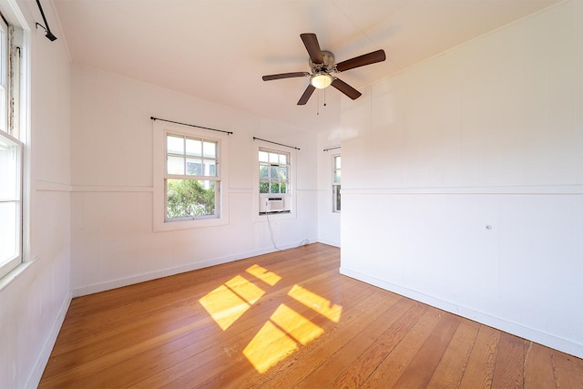 unfurnished room featuring cooling unit, hardwood / wood-style flooring, and ceiling fan