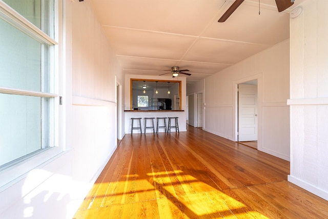 unfurnished living room with ceiling fan and hardwood / wood-style floors