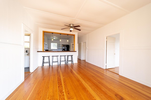 unfurnished living room featuring wood-type flooring and ceiling fan