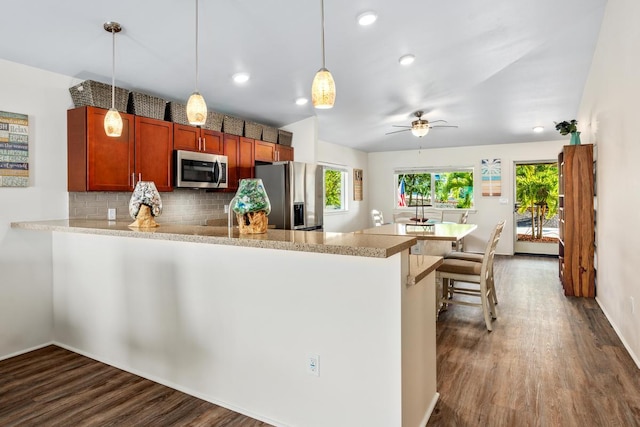 kitchen with kitchen peninsula, ceiling fan, pendant lighting, and appliances with stainless steel finishes