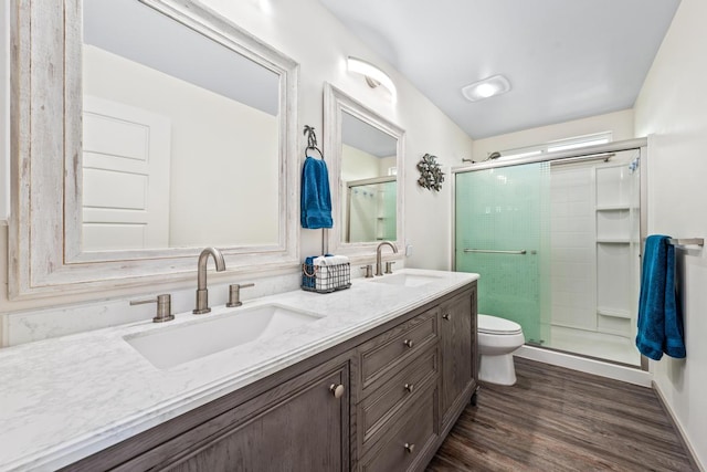 bathroom with hardwood / wood-style floors, vanity, an enclosed shower, and toilet