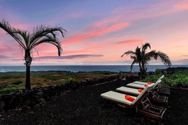 yard at dusk featuring a water view