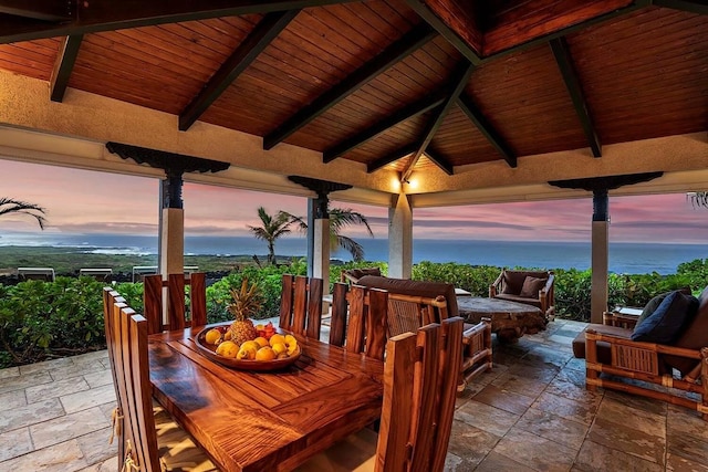 patio terrace at dusk featuring a water view