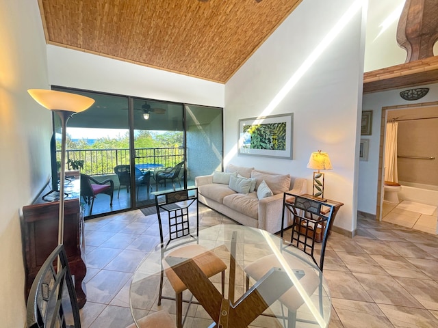 tiled living room with wood ceiling and a towering ceiling