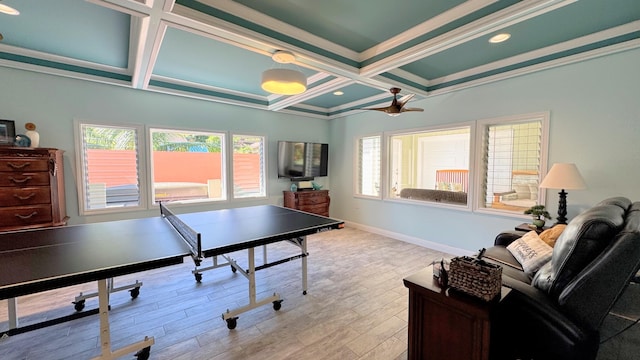 game room with coffered ceiling, ceiling fan, light wood-type flooring, ornamental molding, and beam ceiling