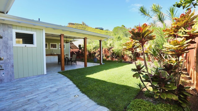 view of yard featuring a patio area and ceiling fan