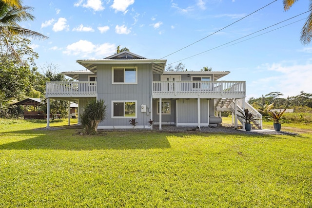 rear view of house with a wooden deck and a lawn