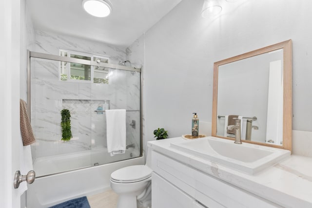 full bathroom featuring vanity, toilet, and combined bath / shower with glass door