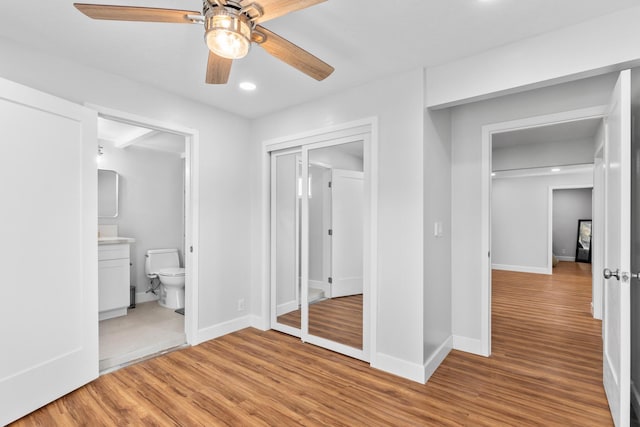 unfurnished bedroom featuring ceiling fan, light hardwood / wood-style floors, and ensuite bath