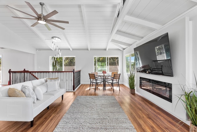 living room with ceiling fan, dark hardwood / wood-style flooring, and lofted ceiling with beams