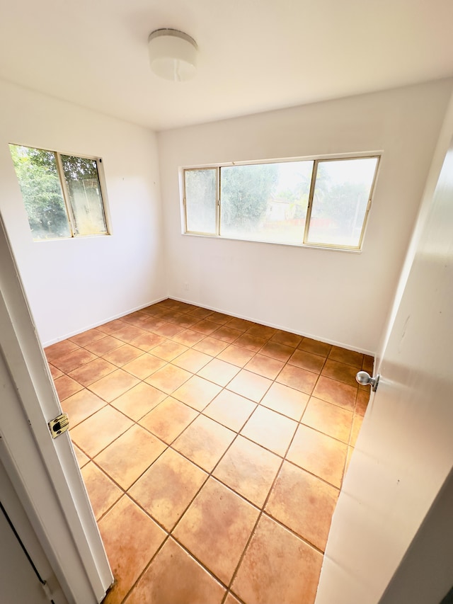 tiled empty room with a wealth of natural light