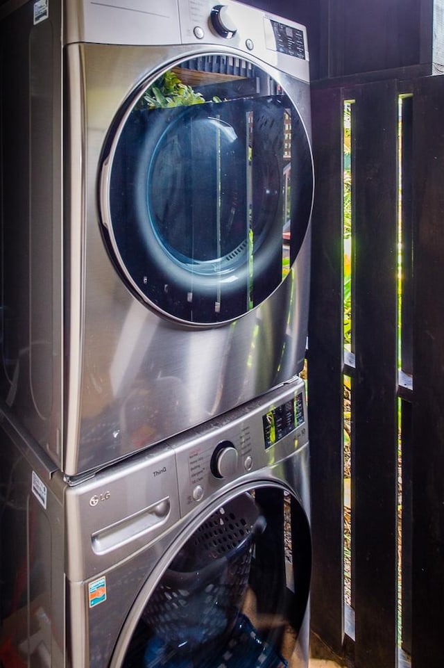 clothes washing area featuring stacked washer and clothes dryer