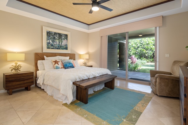 bedroom with access to exterior, a raised ceiling, and ceiling fan