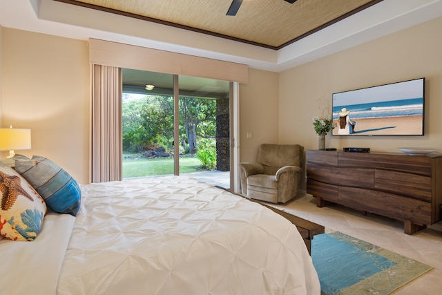 bedroom with access to exterior, a raised ceiling, and ceiling fan