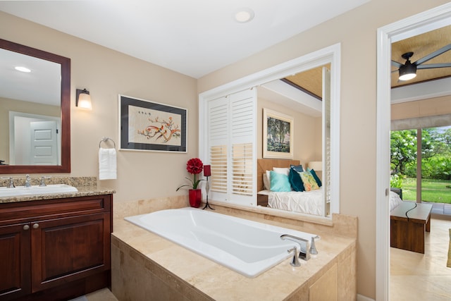 bathroom with vanity, tile patterned flooring, and tiled bath