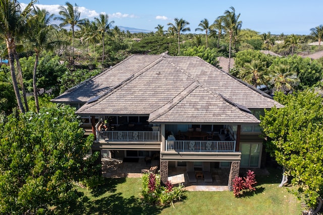 rear view of property featuring a balcony, a lawn, and a patio area