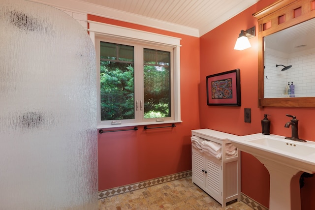 bathroom featuring walk in shower, crown molding, and sink