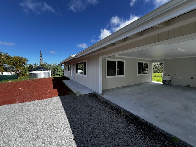 view of side of home with a carport and sink