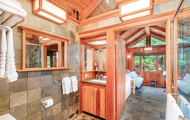 bathroom with wood ceiling, vaulted ceiling, vanity, and ensuite bathroom