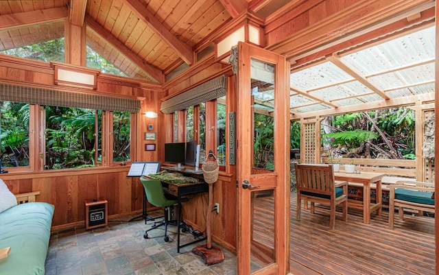 office space with vaulted ceiling with beams, wooden ceiling, wooden walls, and stone finish floor