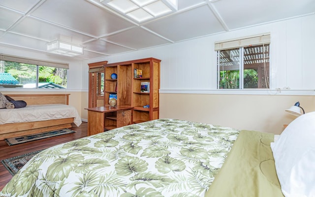 bedroom with coffered ceiling and wood finished floors