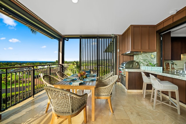 balcony featuring grilling area, exterior bar, and exterior kitchen