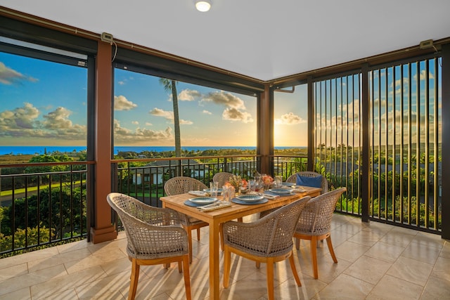 sunroom featuring a water view