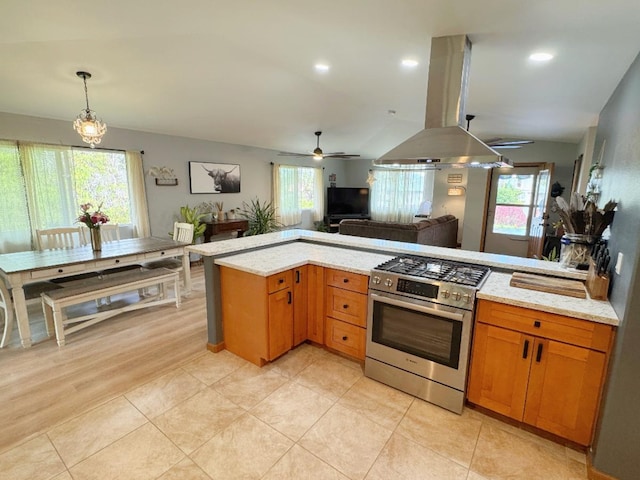 kitchen with island exhaust hood, ceiling fan, a healthy amount of sunlight, and high end stainless steel range oven