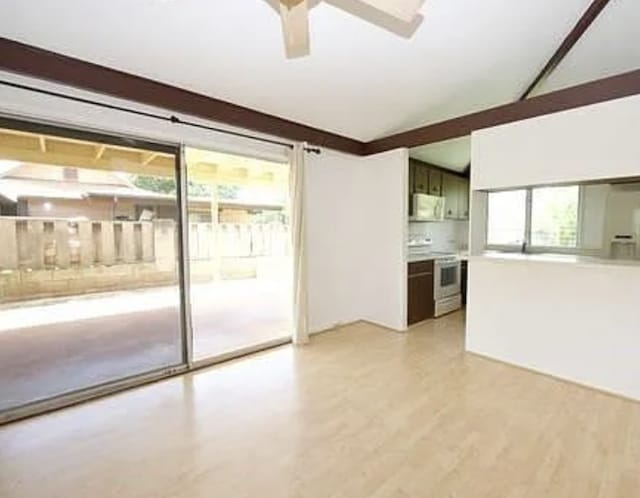 unfurnished living room with ceiling fan, light wood-type flooring, and a wealth of natural light