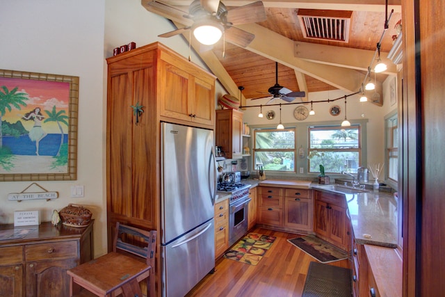 kitchen with sink, hanging light fixtures, vaulted ceiling with beams, appliances with stainless steel finishes, and wood ceiling