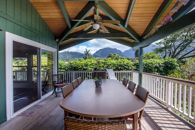 wooden deck featuring a mountain view and ceiling fan