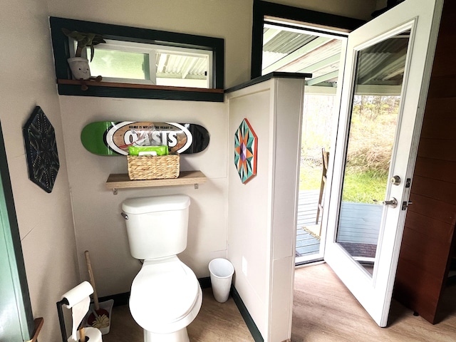 bathroom with wood finished floors, toilet, and baseboards