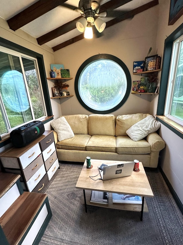 living room with ceiling fan, baseboards, and beam ceiling