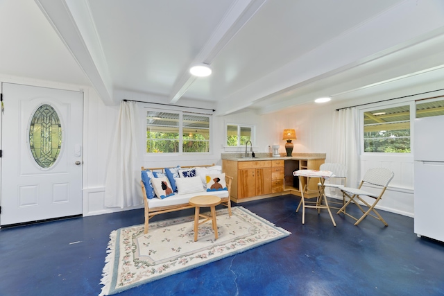 living area with beam ceiling, breakfast area, and sink